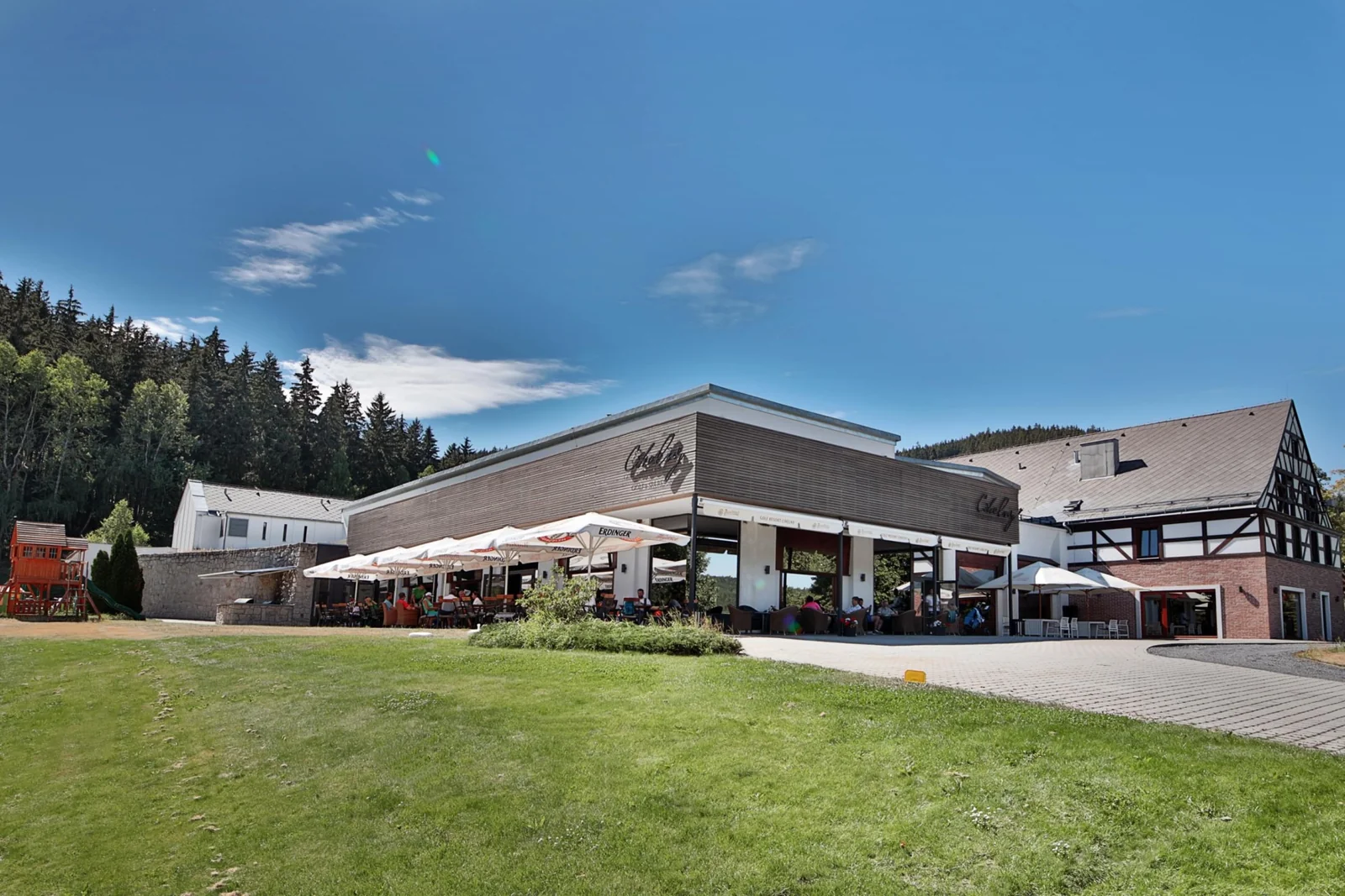 Cihelny Golf & Wellness Resort – Budova golfového resortu s terasou a přilehlou zelení.
