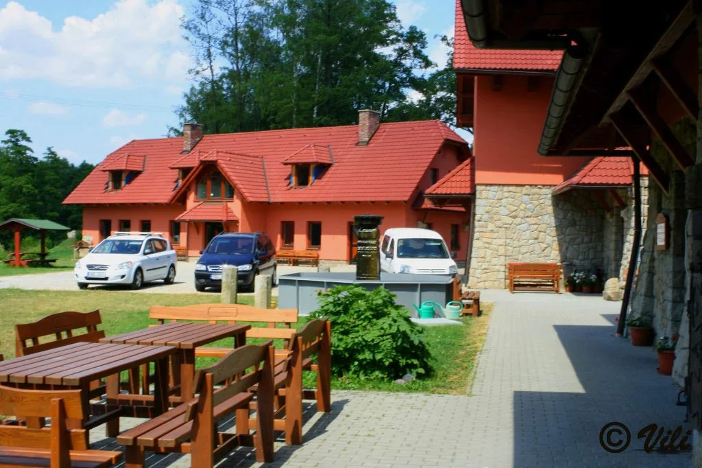 Dočkalův mlýn – Exteriér mlýna s terasou; viditelný fotografický podpis ponechán.