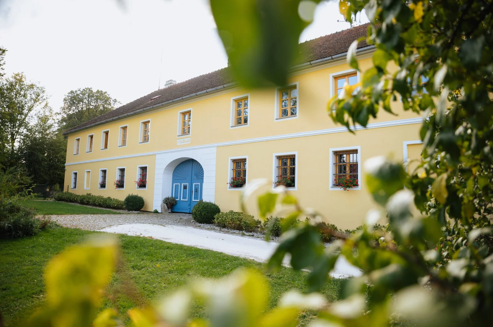 Venkovská usedlost Zahrádka – Celkový exteriér historické usedlosti s modrými vraty.